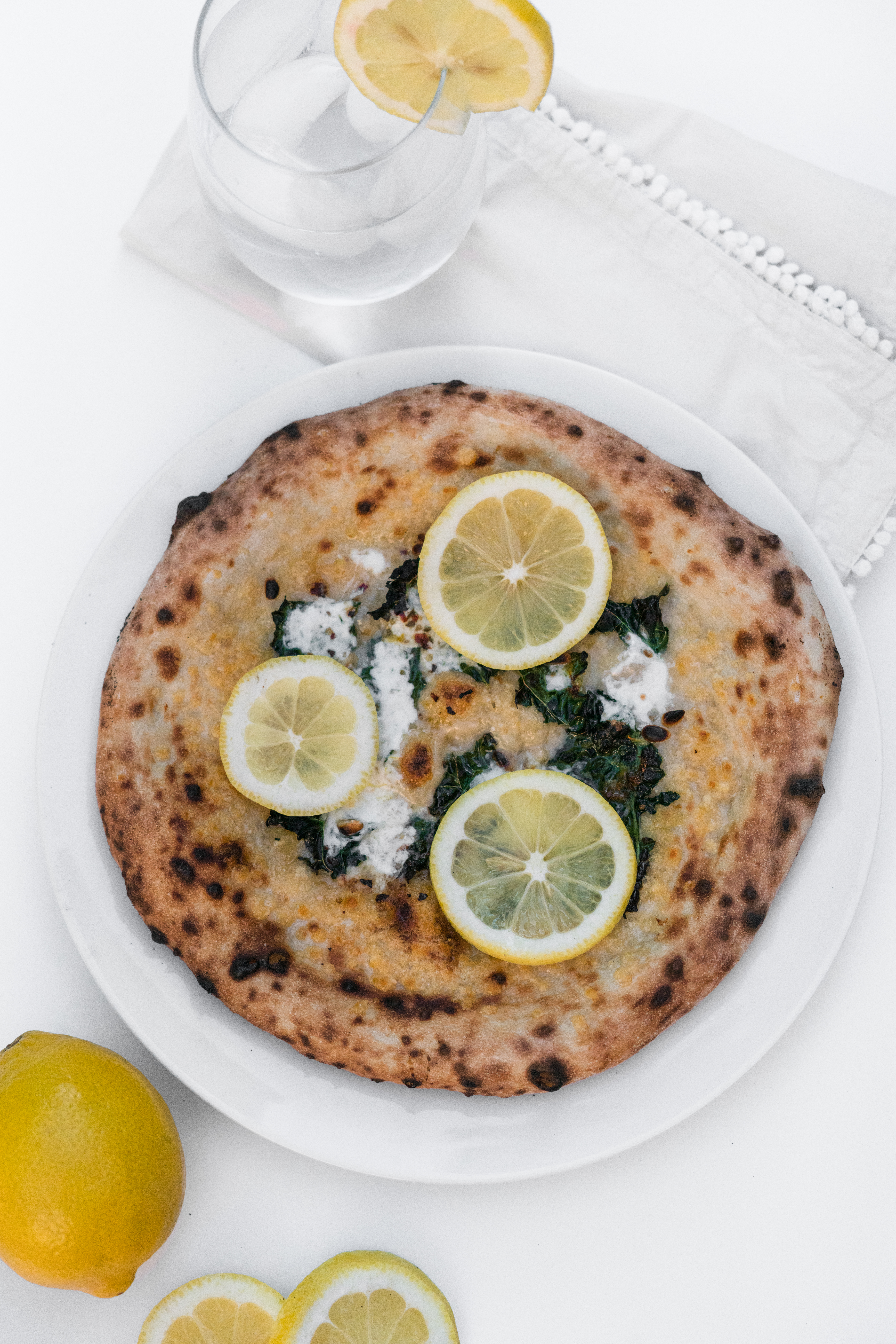 Kale lemon pizza on white table cloth